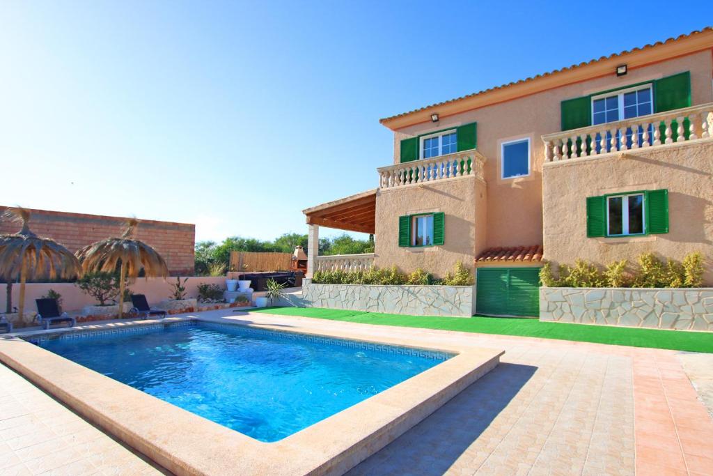 a villa with a swimming pool in front of a house at Villa Domingos by Slow Villas in Calas de Mallorca