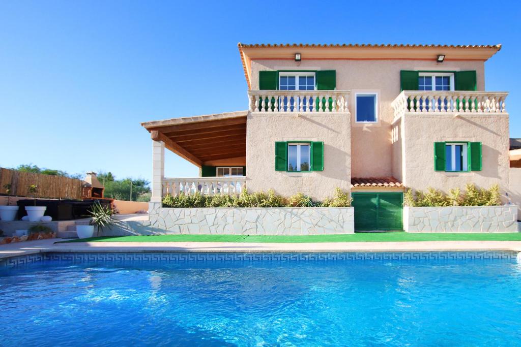 una villa con piscina di fronte a una casa di Villa Domingos by Slow Villas a Calas de Mallorca
