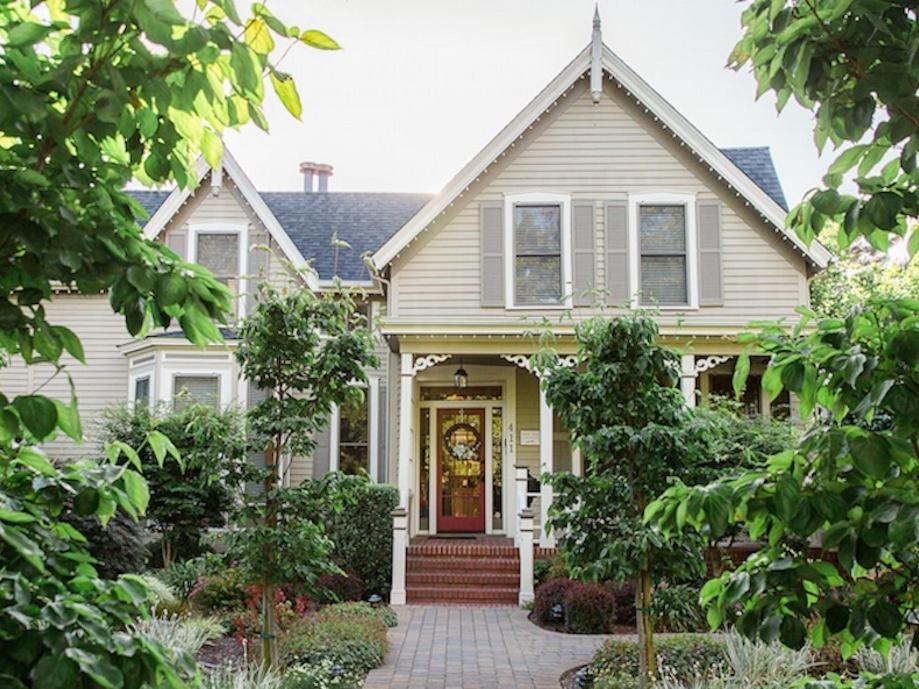 a white house with a yellow door and a porch at Inn on Randolph in Napa