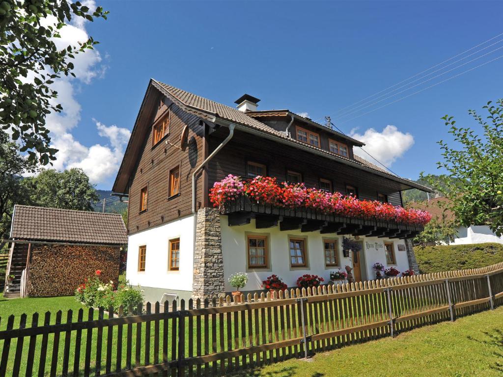 une maison avec des fleurs sur son côté dans l'établissement Ferienhaus Nickl, à Weißbriach