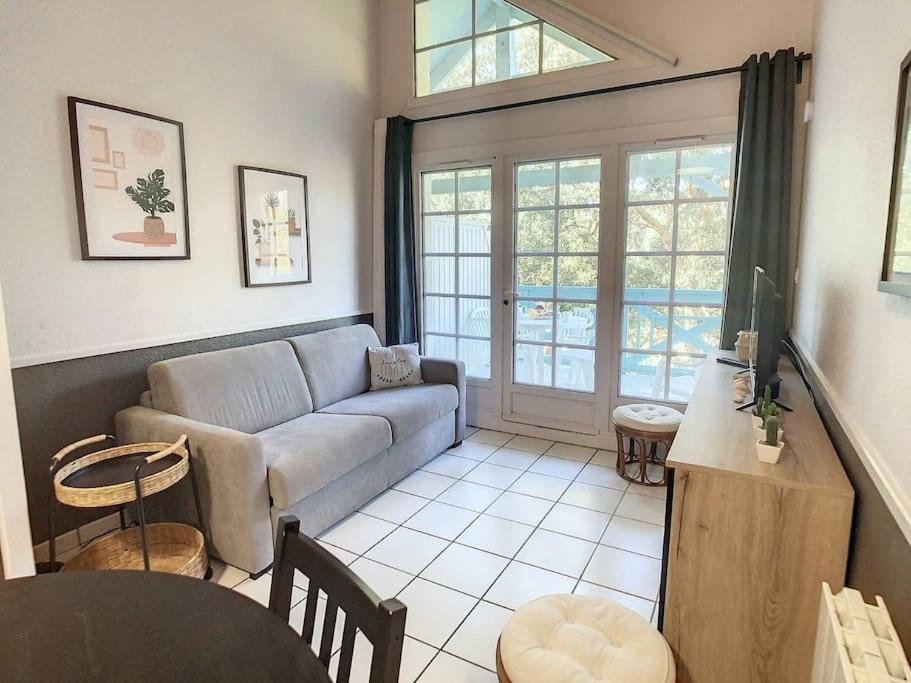 un salon avec un canapé et une table dans l'établissement M-Fairway 01-Moliets Duplex 6 personnes dans résidence avec piscines proche du golf, à Moliets-et-Maa