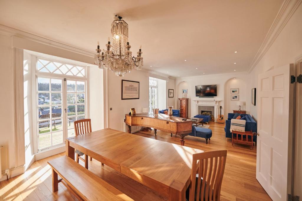 a dining room with a table and a living room at Fernhill House- Beautiful period property with 5 bedrooms and lovely views in Laugharne