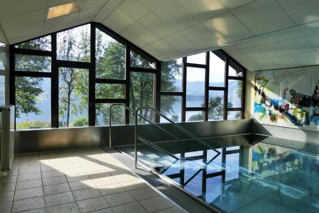 a room with a glass floor with a swimming pool at DANIELA Seeblick Appartement Haus Hänsel Gretel am Ossiacher See, Hallenbad, Skiarena Gerlitzen in Stiegl