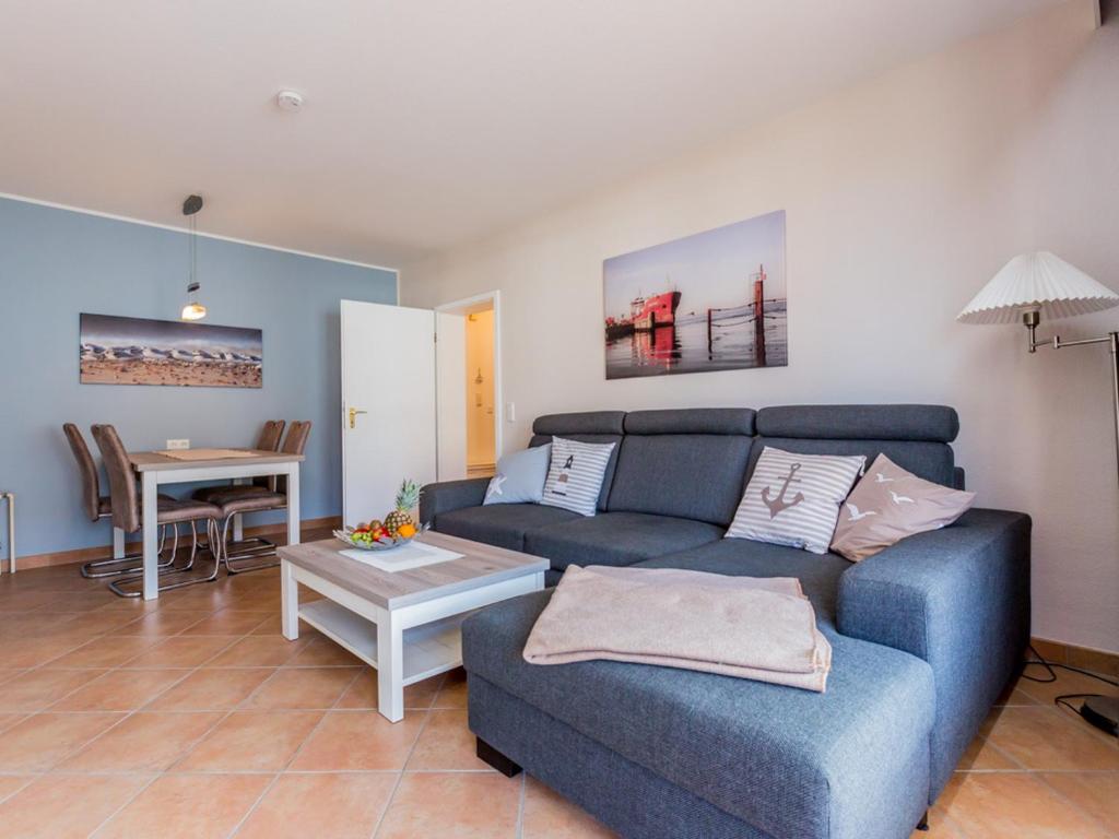 庫克斯港的住宿－Haus Strandnixe，客厅配有蓝色的沙发和桌子