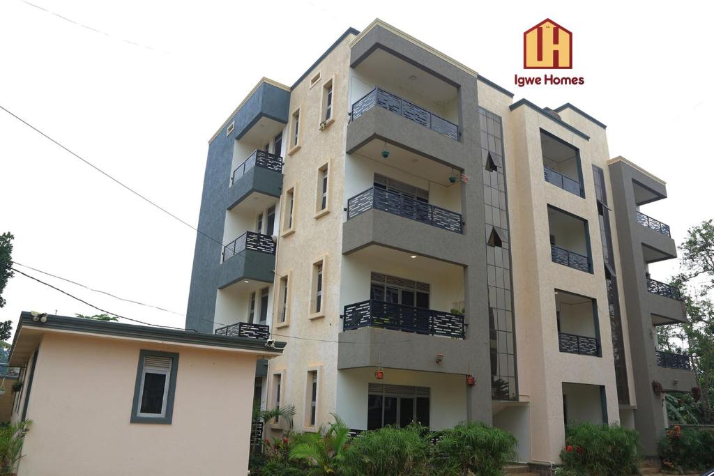 an apartment building in front of a white building at Igwe Homes - Kisaasi in Kampala