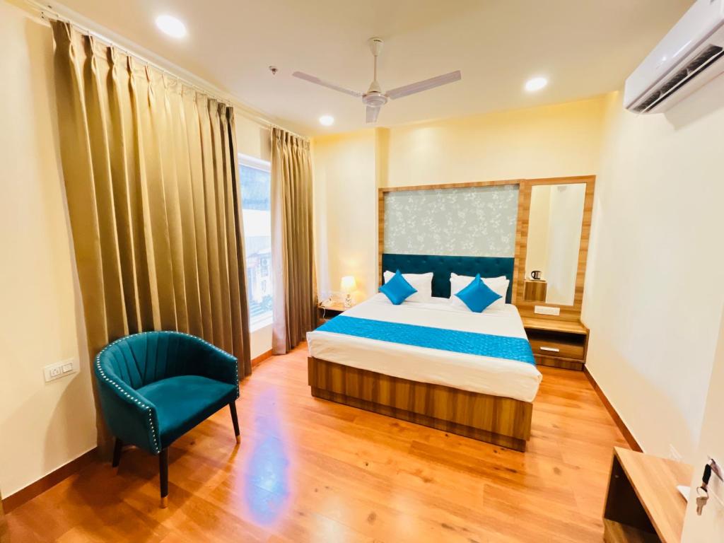 Hotel The Orchid Tree Amritsar - walking from Golden Temple في أمريتسار: غرفة نوم بسرير وكرسي ازرق