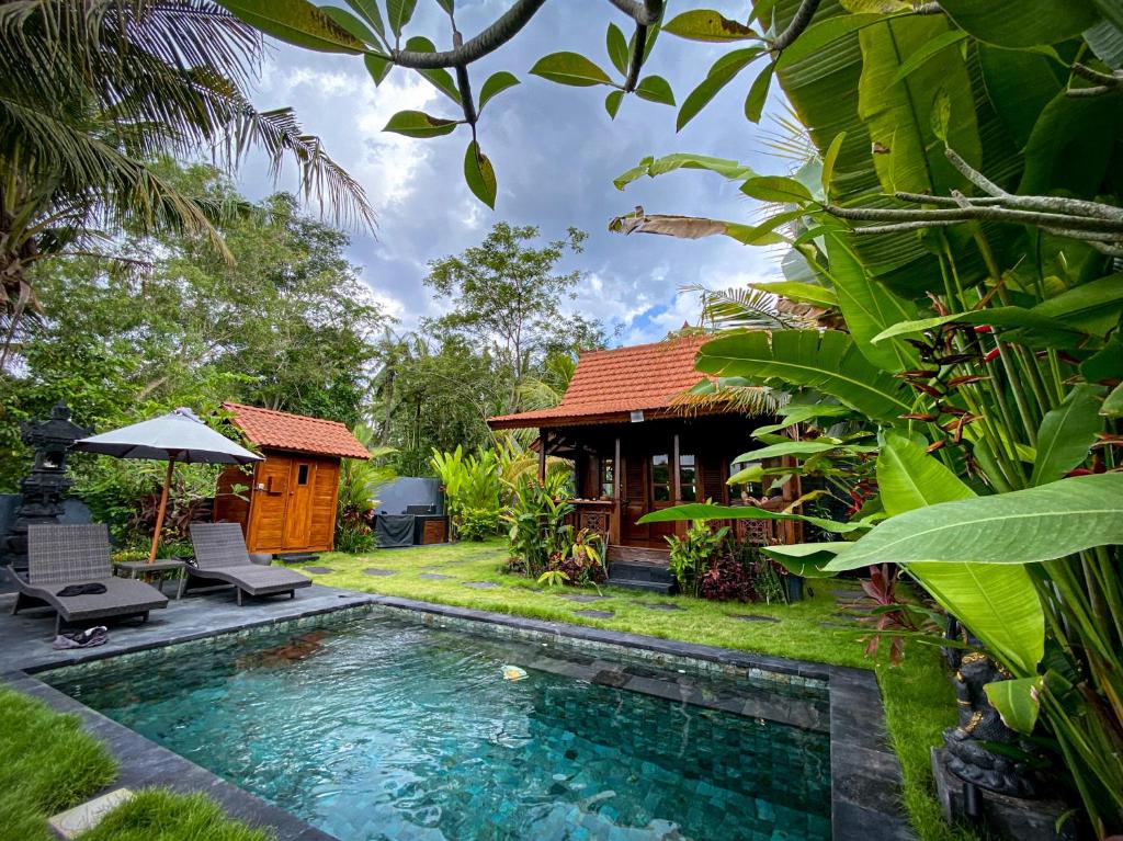 a villa with a swimming pool and a house at The Hidden Escapes Manggis- Stunning Tiny Home set on a Lake with Mountain View, Private Sauna, Pool, Bicycles, BBQ & Butler! in Padangbai
