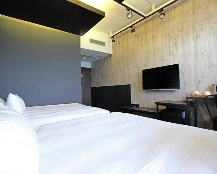 a bedroom with a white bed and a flat screen tv at 窗外的海 - 海洋公園旁 in Yanliau
