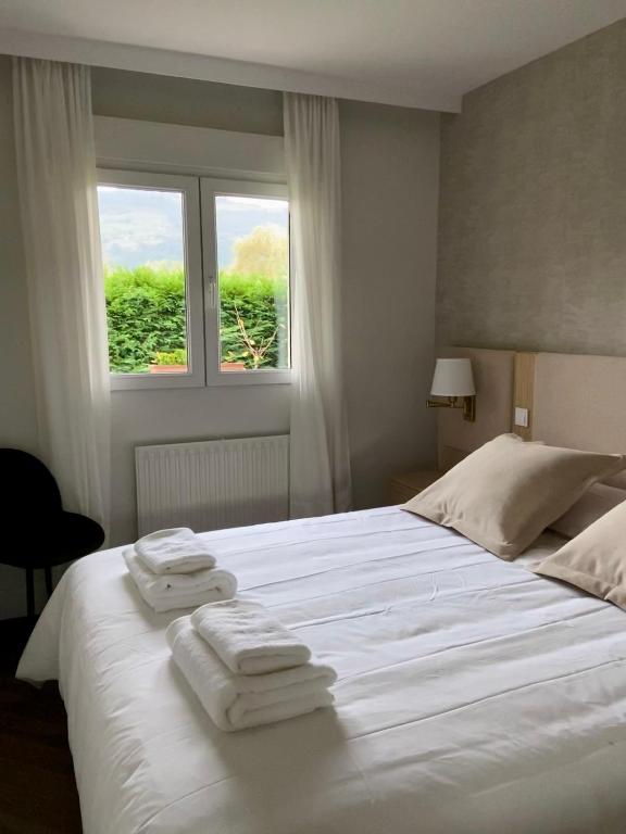- une chambre avec un grand lit blanc et des serviettes dans l'établissement La casita del Pisueña, à La Cueva