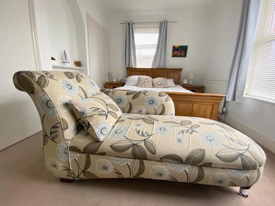 a couch in a bedroom with a bed at Boardwalk in Kent