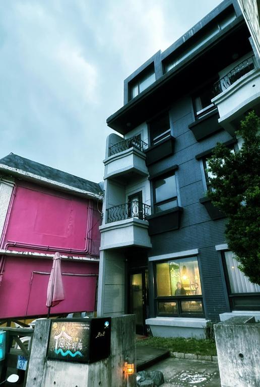an apartment building with a pink and purple facade at 窗外的海 - 海洋公園旁 in Yanliau