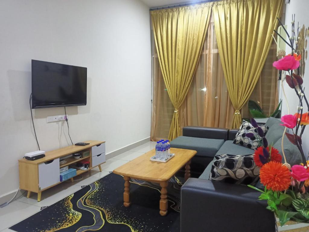 uma sala de estar com um sofá e uma televisão em Homestay KiTa malays only em Alor Setar