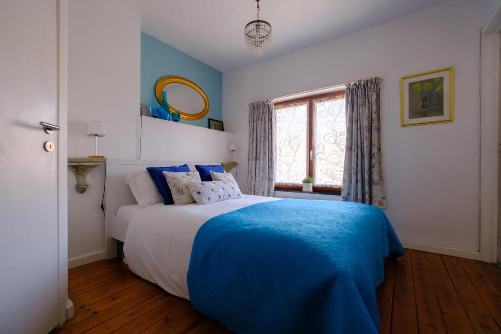 a bedroom with a bed with a blue blanket at Collier's BnB in Bruges