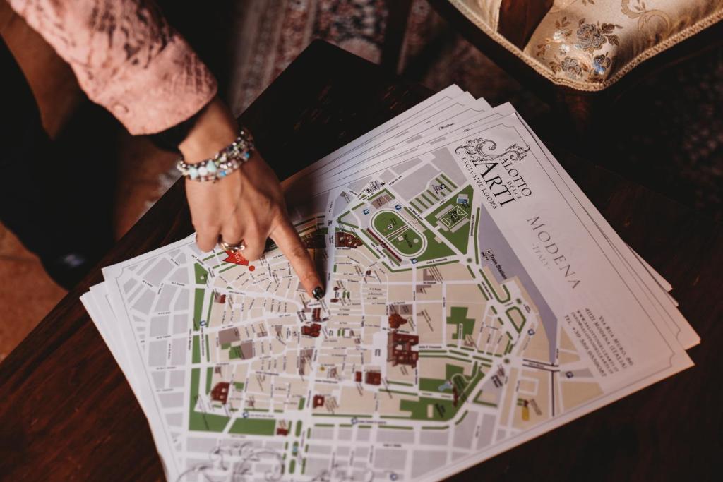 una mujer está mirando un mapa en una mesa en Salotto delle Arti, en Módena