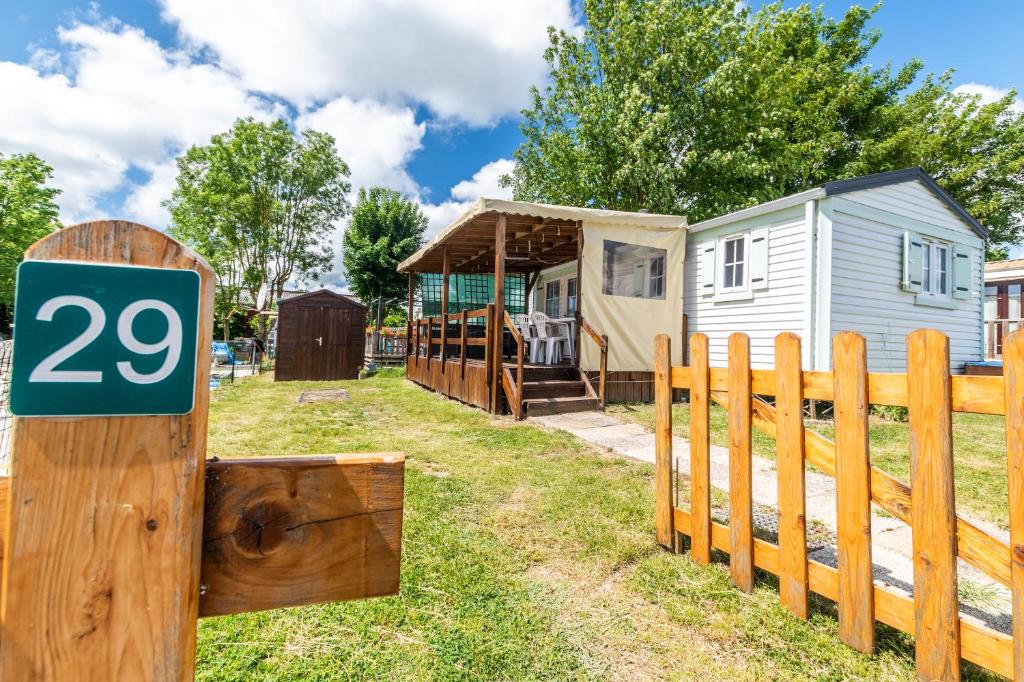 a sign on a fence next to a tiny house at Mobil Home Le Tokyo in Noyelles-sur-Mer