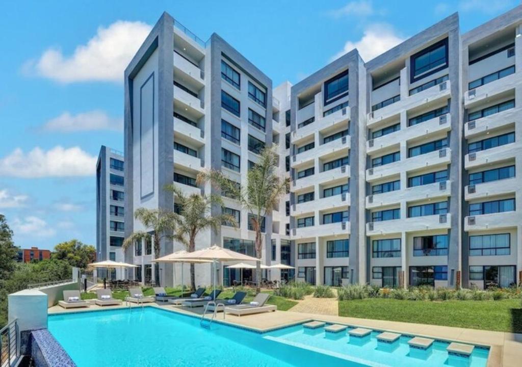 uma imagem de um edifício de apartamentos com piscina em Regency Apartment em Pretoria