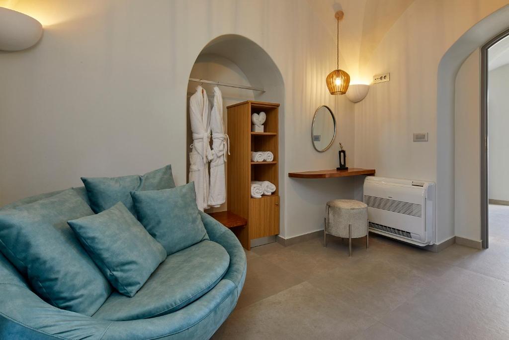 un soggiorno con divano blu e specchio di Aecon Suites a Éxo Goniá