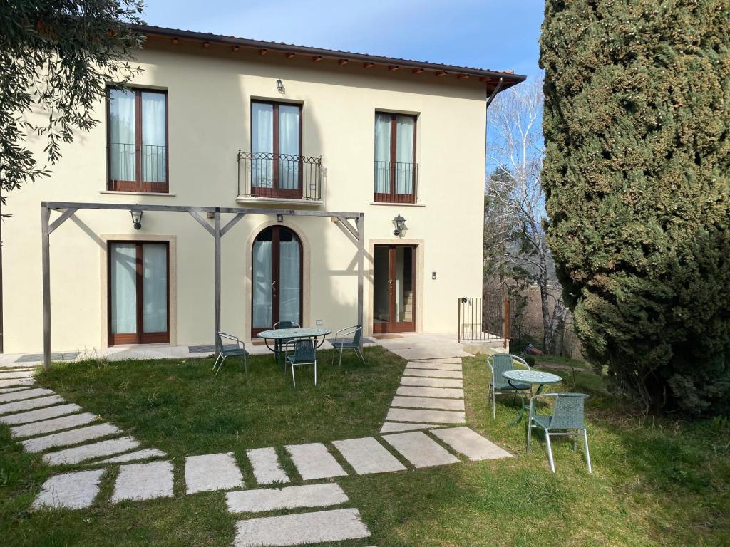 a house with chairs and tables in front of it at Residenza Cipressi e Olivi in Verona