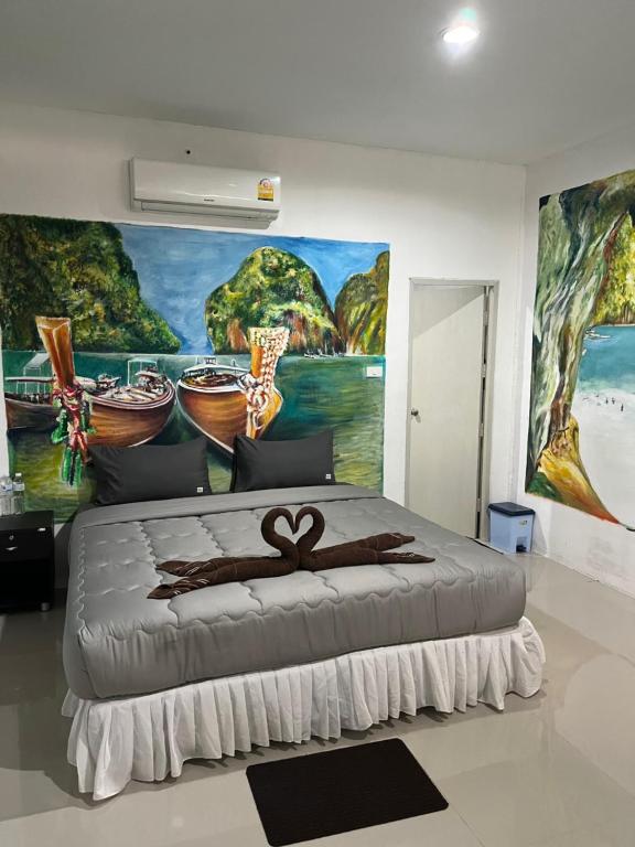 - une chambre avec un grand lit orné d'une peinture murale dans l'établissement Reggaeinn, sur les Îles Phi Phi