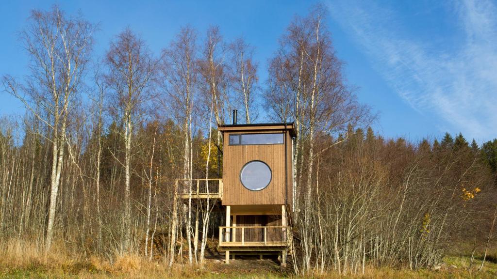 a tree house sitting in the middle of a field at Fuglekassehytta 