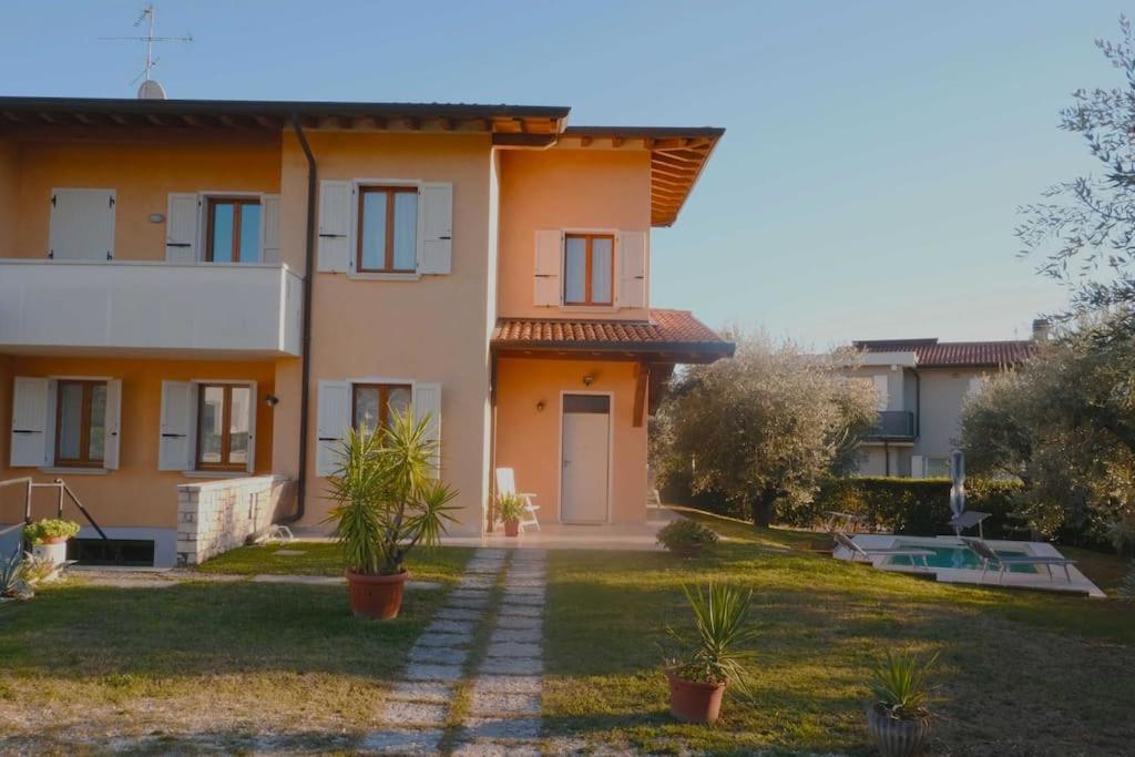 a house with a yard with plants in front of it at Villa Lidia - tra il verde e l’azzurro. in San Felice del Benaco