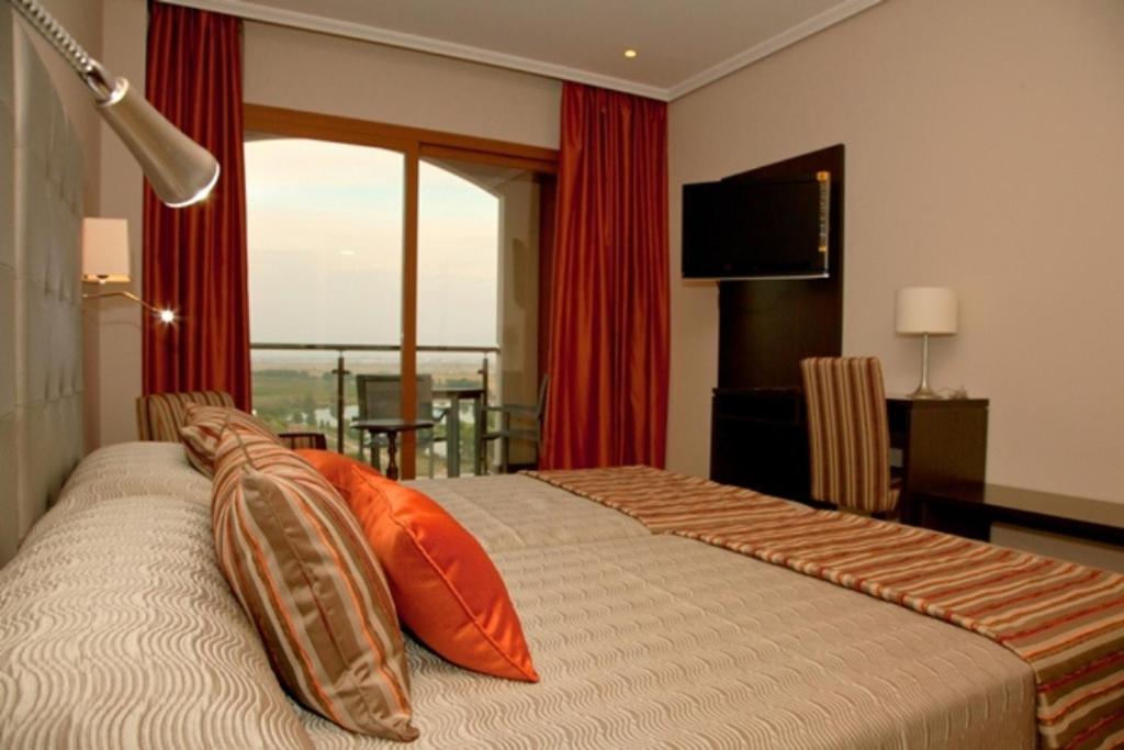 una camera d'albergo con letto e cuscini arancioni di Hotel Rural Quinto Cecilio a Medellín