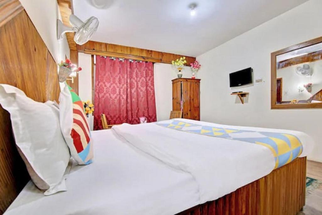 a bedroom with a large bed and a window at Hotel Gangri By WB Inn in Manāli