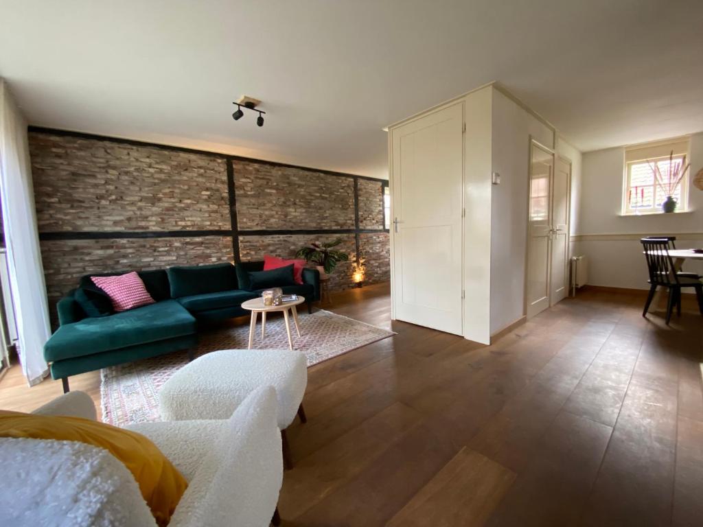 sala de estar con sofá y mesa en LooSan Lodges Gastenhuis, en Reutum