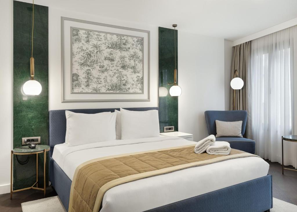Pera Rasso Hotel في إسطنبول: غرفة نوم بسرير كبير وكرسي ازرق