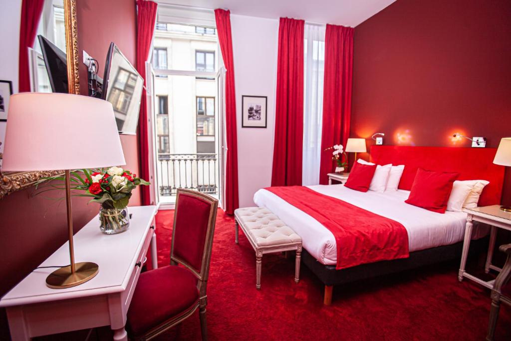 Hôtel Churchill Bordeaux Centre في بوردو: غرفة نوم حمراء مع سرير وطاولة ومكتب