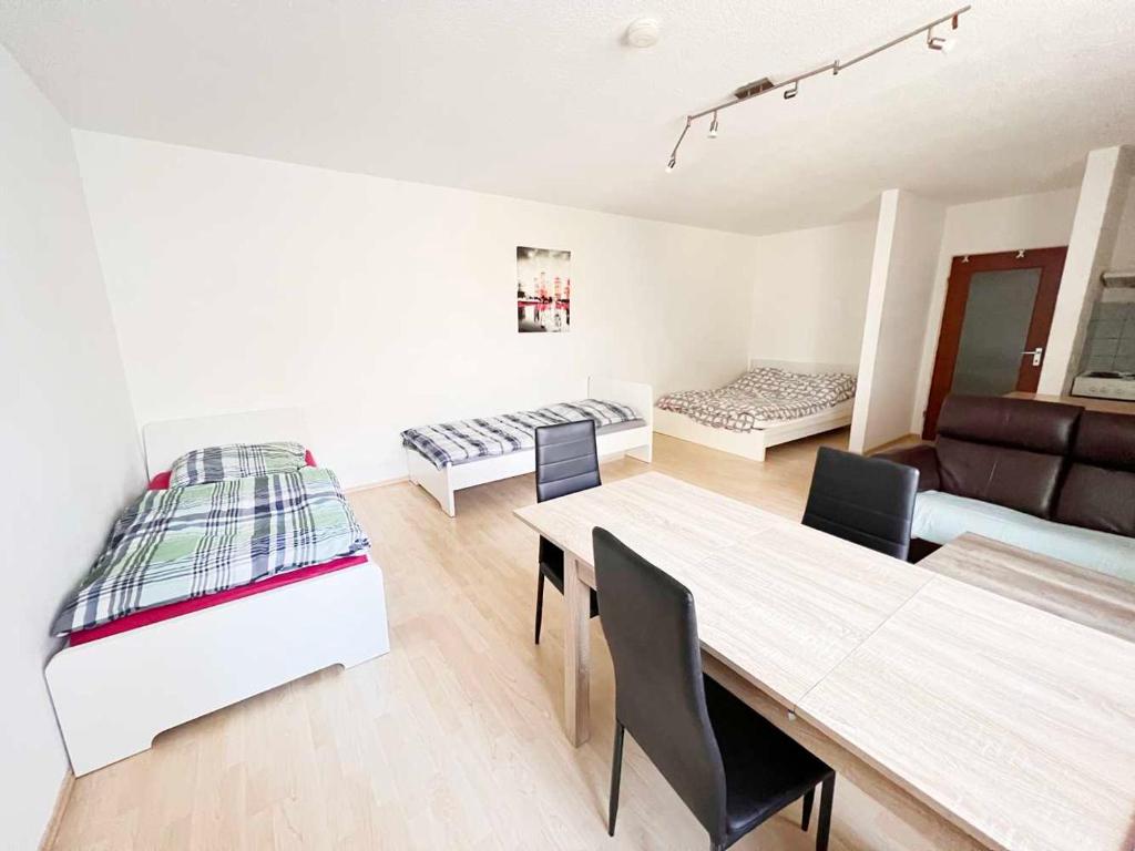un soggiorno con letto, tavolo e sedie di Praktisches Apartment mit Flatscreen TV a Leverkusen
