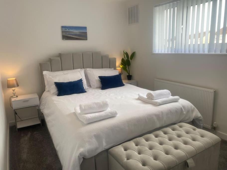 a bedroom with a large white bed with blue pillows at The Hoot Luxury home close to town and beaches in Pembrokeshire