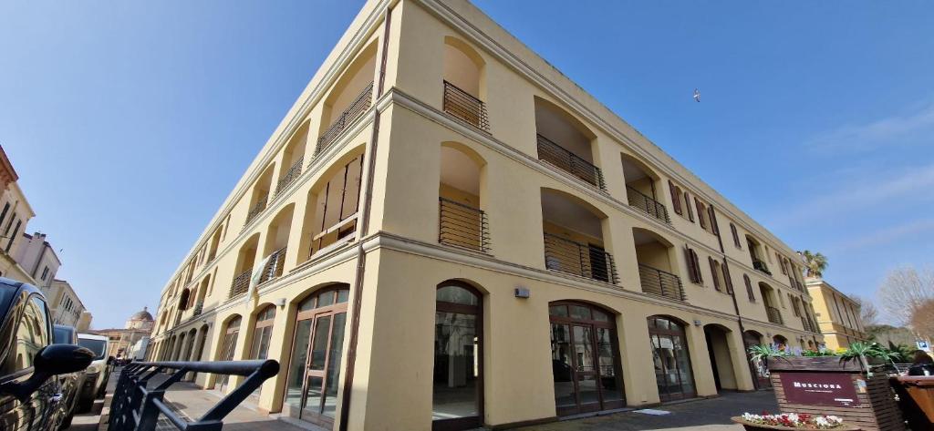 een groot wit gebouw met ramen aan een straat bij Sph24 Appartamento Alghero Via Mazzini in Alghero