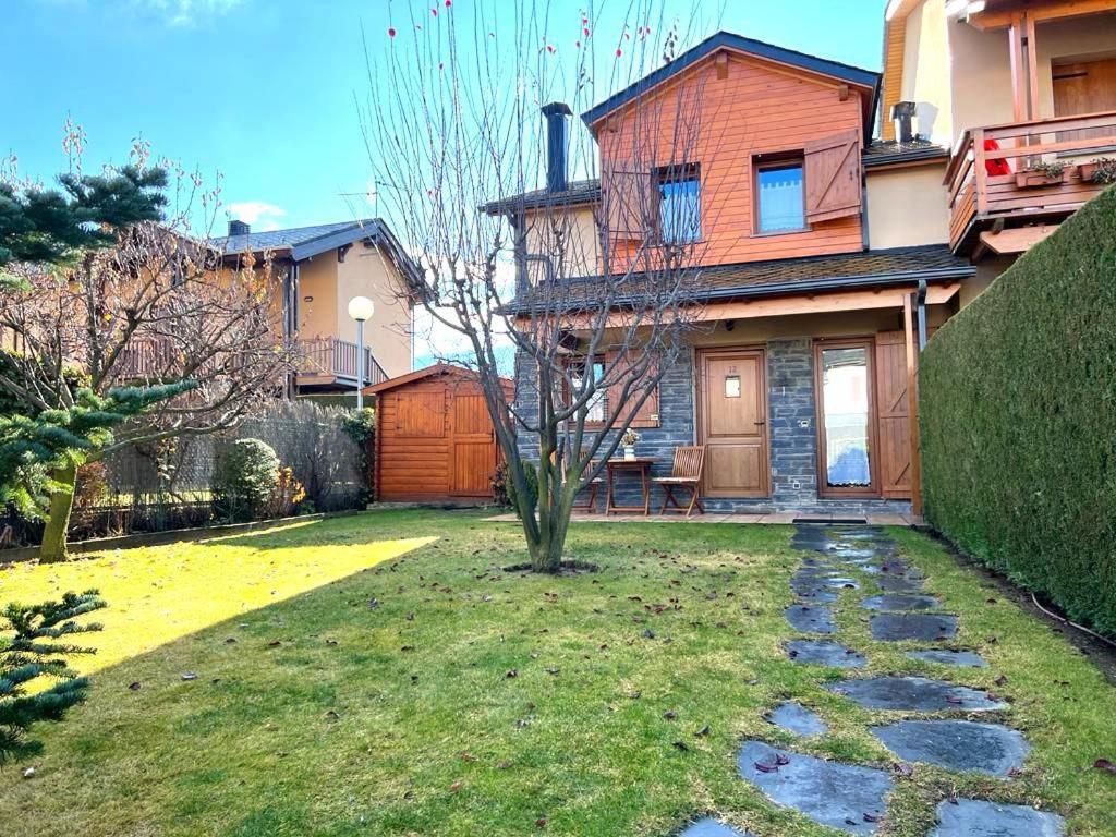 una casa con un patio con un camino de piedra en Bonita casa adosada con gran jardín, en Osséja