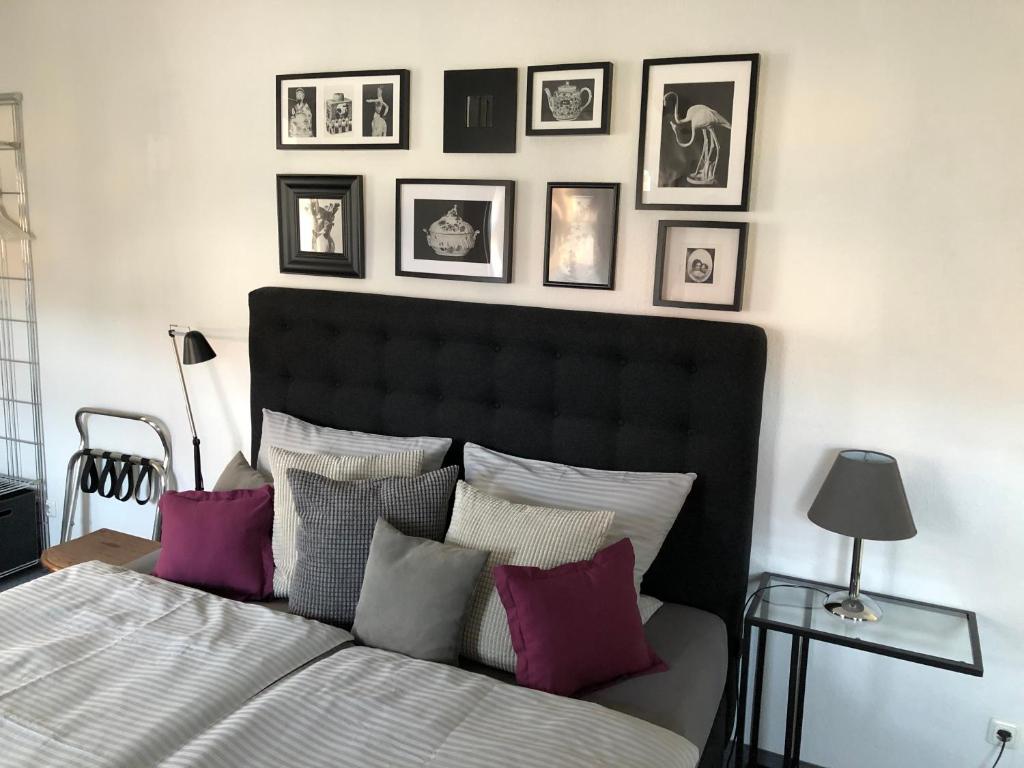 a bedroom with a bed and framed pictures on the wall at Stadthaus Rosengasse in Meißen