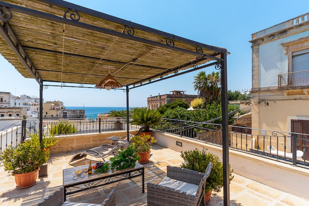a patio with benches and a view of the ocean at L' ATTICO CastroSalento in Castro di Lecce