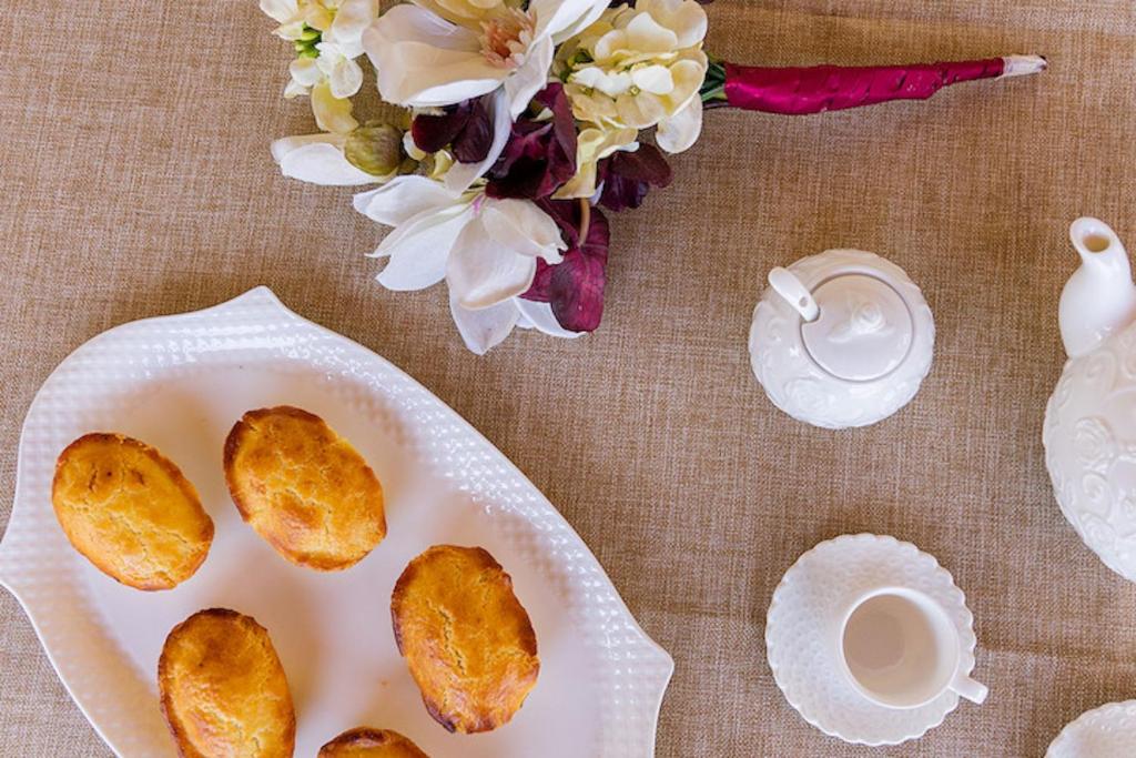 une table avec une assiette de nourriture et de fleurs dans l'établissement Appartamento SupersanoSalento, à Supersano