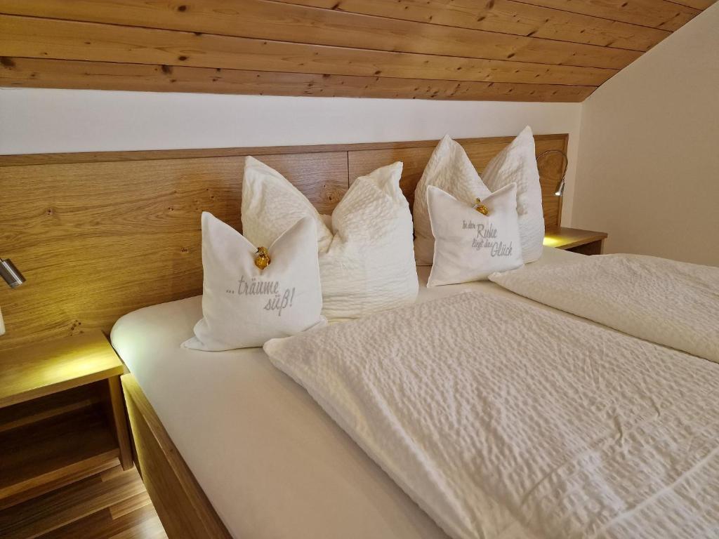 a bed with white pillows on top of it at Bio-Bauernhof Vordergrubenbach - Familie Oberascher in Hintersee