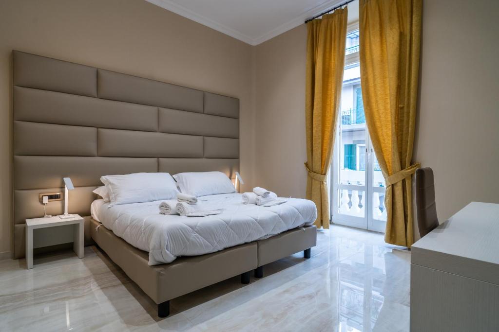 una camera da letto con un letto grande con sopra due animali di peluche di Correnti Boutique Hotel Gold a Sanremo