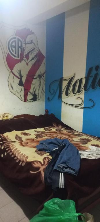 1 dormitorio con 1 cama con una pintura en la pared en Home 1 en San Antonio