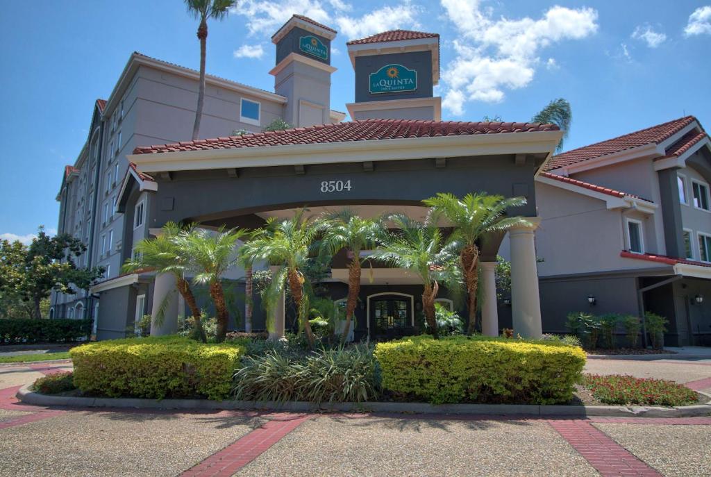 un edificio de hotel con una torre de reloj y palmeras en La Quinta by Wyndham Orlando I Drive/Conv Center en Orlando