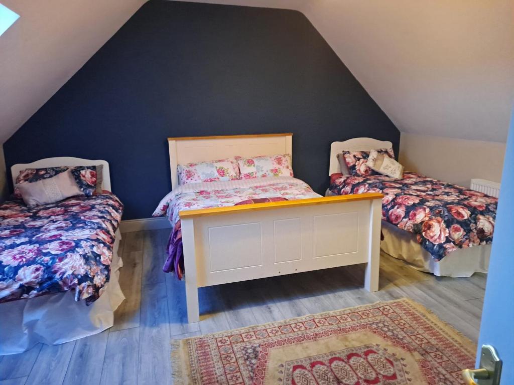 a attic room with two beds and a table at Fearmore view in Kildare