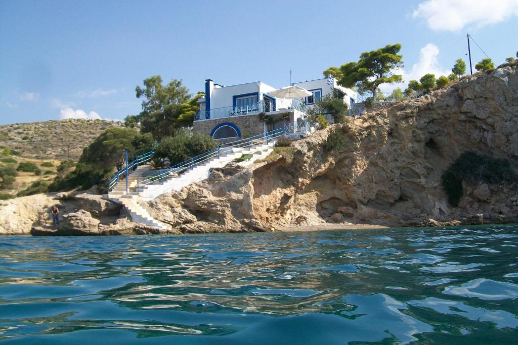a house on a cliff next to the water at Villa Nikolitsa with private beach in Megara