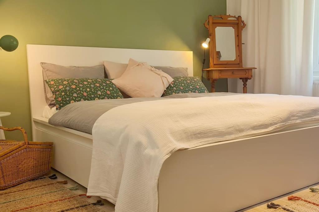 een slaapkamer met een wit bed met kussens en een spiegel bij Cosy Family Apartment in Reichenau