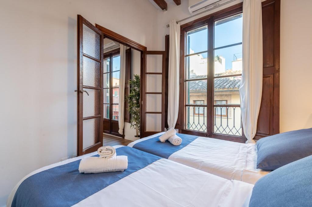 a bedroom with two beds and a large window at Holiday Palma Apartments - TI in Palma de Mallorca