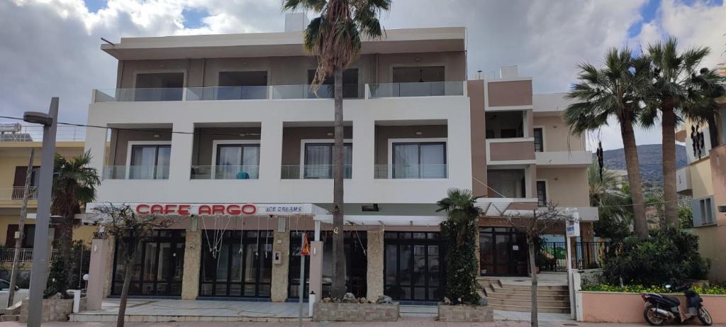 a large white building with palm trees in front of it at Argo Studios in Malia