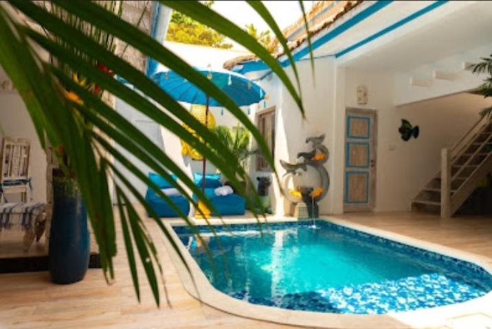 een zwembad in een woonkamer met een plant bij Shray Villa. Legian in Legian