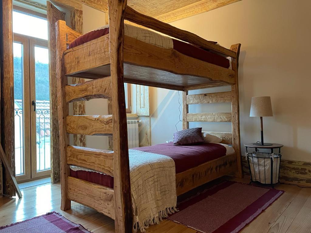 a bedroom with a wooden bunk bed in a house at Casa do Tio Plácido in Valezim