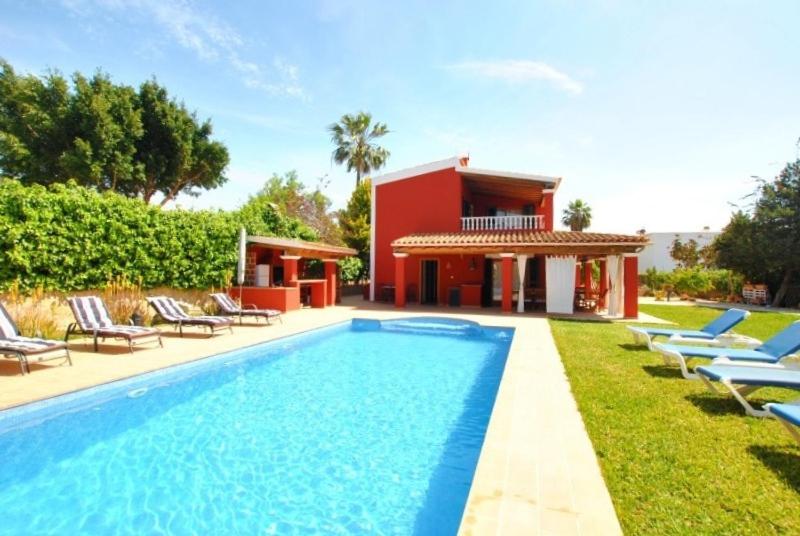 een zwembad met ligstoelen en een huis bij Villa Rosada - Private pool & Barbecue in San Jose de sa Talaia