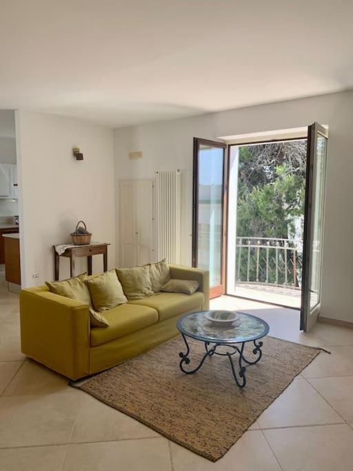 a living room with a yellow couch and a table at Casa della Resistenza in Presicce